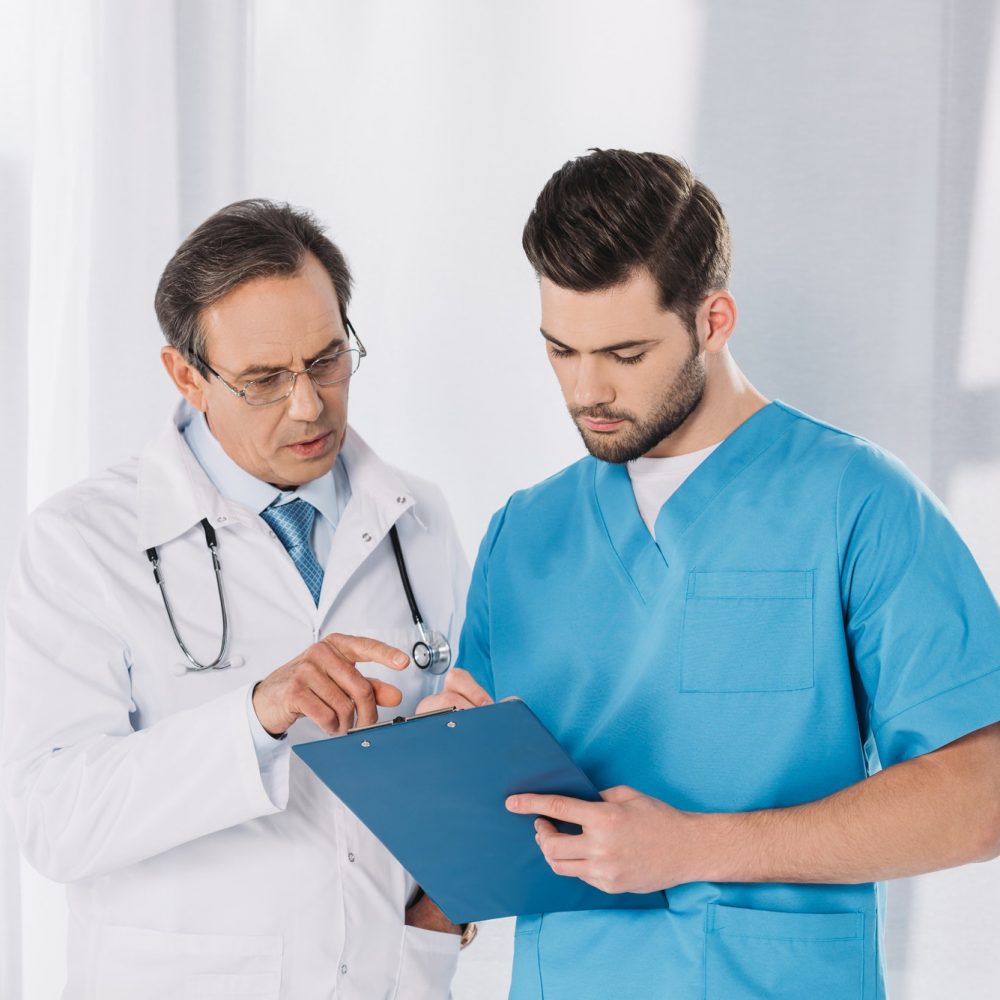 male-doctor-and-nurse-looking-at-clipboard.jpg
